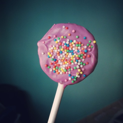Oreo cookie pop with lavender coating and rainbow sprinkles!